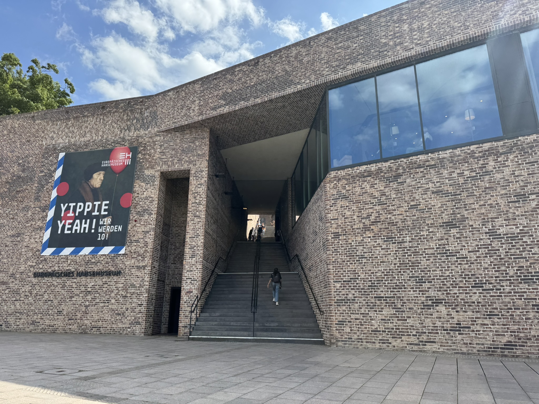Ein Backsteingebäude mit einem großen Durchgang in der Mitte, wo eine Treppe hinauf führt.