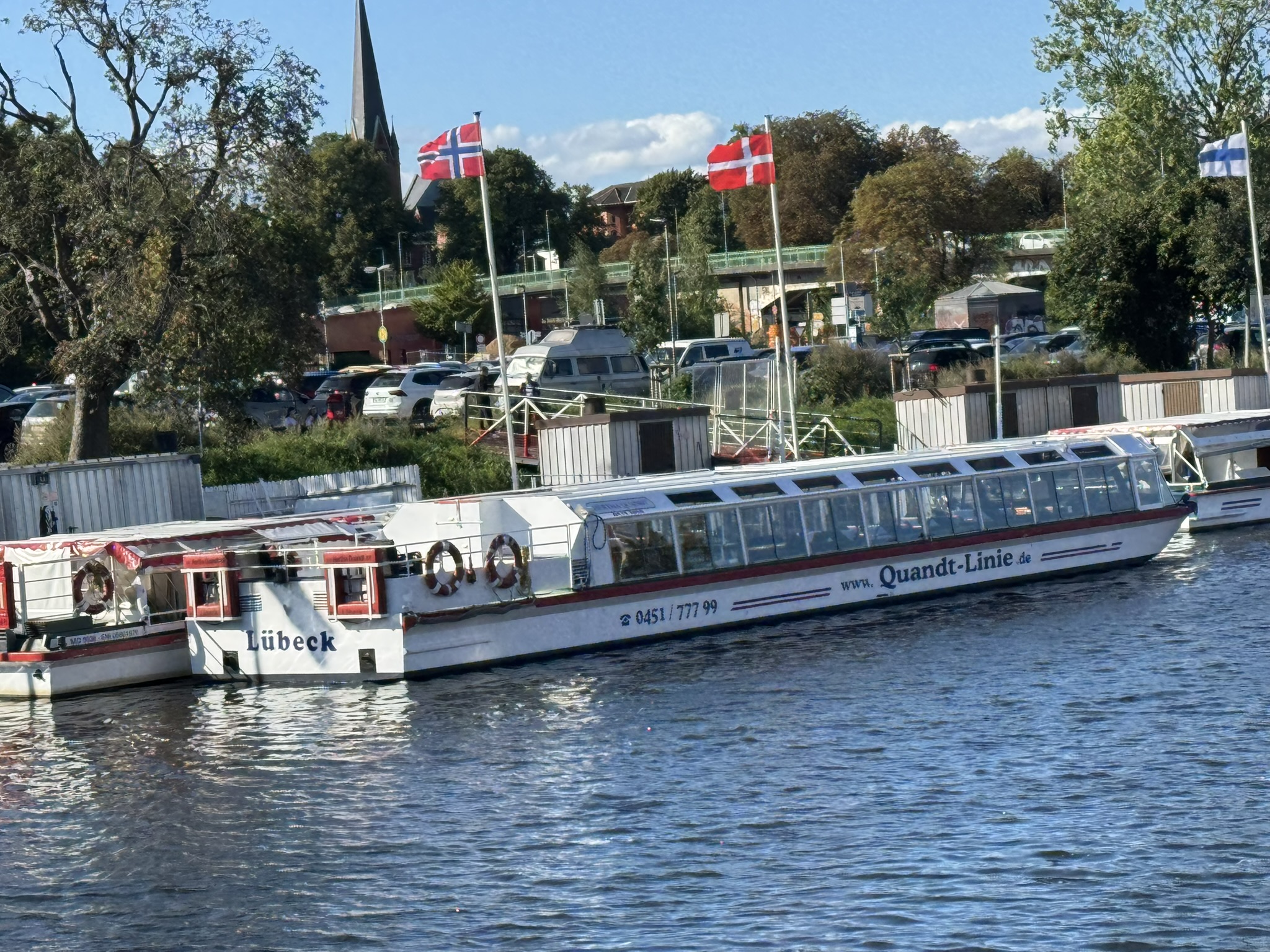 Auf diesem Bild ist ein Schiffsanleger samt eines weißen Passagierschiff zu senen.
